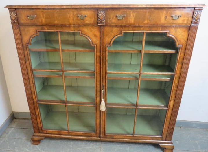 A good quality Georgian Revival low glazed bookcase, with crossbanded inlay and shell carved