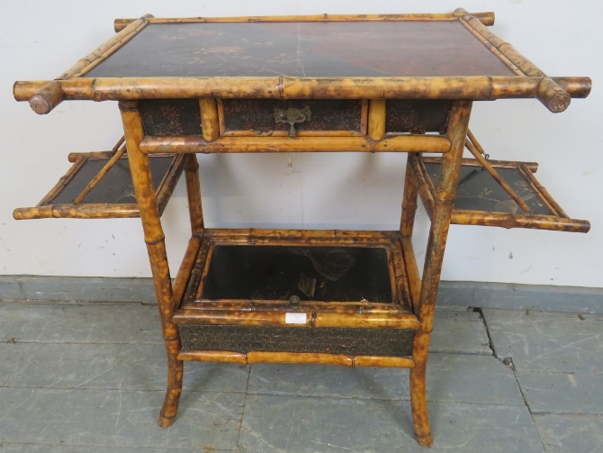 A 19th century colonial bamboo two-tier occasional table, featuring black lacquer panels hand