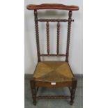 A 19th century Arts & Crafts walnut rush-seated prix-dieux with velvet armrest and ball turned