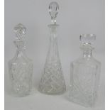 Three cut glass decanters with stoppers. Tallest 50cm high. Condition report: Chips to stopper of