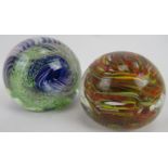 Two multicoloured glass paperweights one with green and blue scroll form and etched mark to base. (