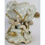 A late 19th/early 20th century German porcelain centrepiece, cherubs and lilies, gilt-trimmed,
