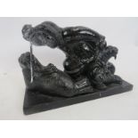 A cast metal sculpture of an Inuit attacking a family of walruses, signed W.E. Height 19cm. Length