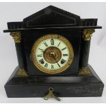 An antique American striking mantel clock with blackened steel case and Ansonia movement. Key and