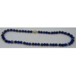 A fine AAAA quality faceted cut lapis lazuli necklace with 14ct yellow gold ball clasp set with