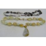 A Chinese necklace made up of irregular shaped citrine stones & baroque pearls with a jade pendant