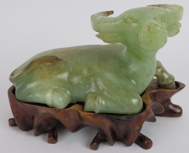 A Chinese carved celadon Jade recumbent water Buffalo, Ming style but likely Qing, resting on a