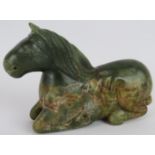 A Chinese carved spinach Jade recumbent horse, Ming style but likely Qing, 16cm long x 10cm high.