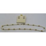 A strand of pearls with a 14ct gold ball clasp and matching spacers, boxed. Approx 16" long,