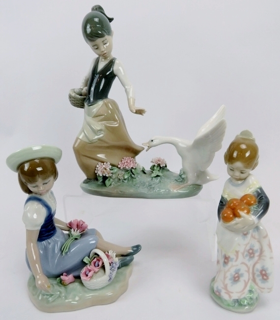 Three Lladro porcelain figures. Comprising a girl with goose, 21 cm height, girl with flowers, 16 cm