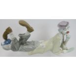 A Lladro porcelain figure of a clown. Depicted laying down with one foot resting on a ball. 15 in (