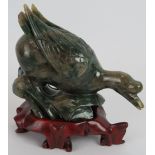 A Chinese carved Mottled spinach Jade duck on a naturalist base, Ming style but likely 20th century,