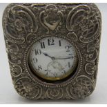 A silver cased pocket watch holder, indistinct hallmarks, embossed with scrolls & foliate