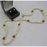 A pearl necklace interspersed with 9 faceted citrine stones and 18 yellow metal spacers. 14ct yellow