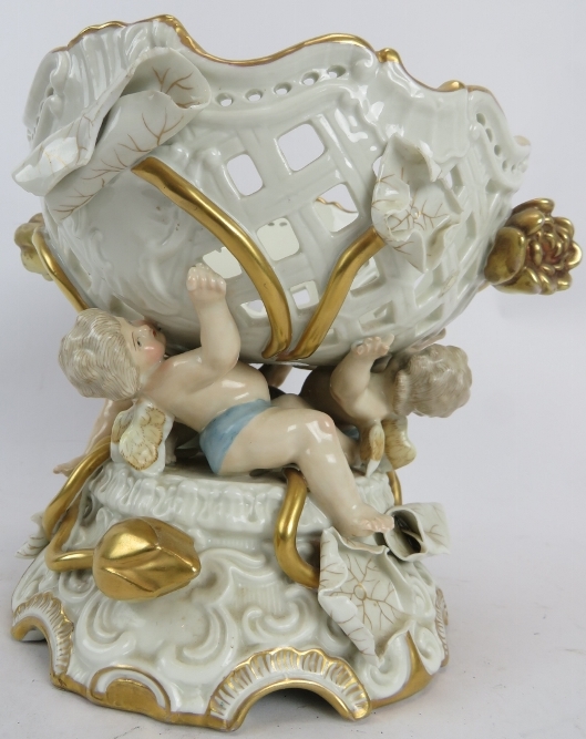 A late 19th/early 20th century German porcelain centrepiece. Decorated with cherubs and lilies,