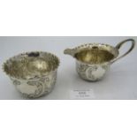 A silver matching cream jug and sugar bowl, engraved with scrolls and foliate design. Sheffield