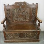 A 19th century high back oak settle, ornately carved in the 17th century taste with figural scene