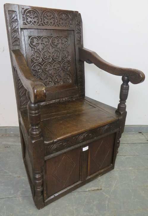A 17th century and later oak wainscot chair, with relief carved panel back, above a box base with