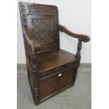 A 17th century and later oak wainscot chair, with relief carved panel back, above a box base with
