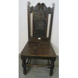 An 18th century oak hall chair, the relief carved back depicting a mythical bird, on turned and