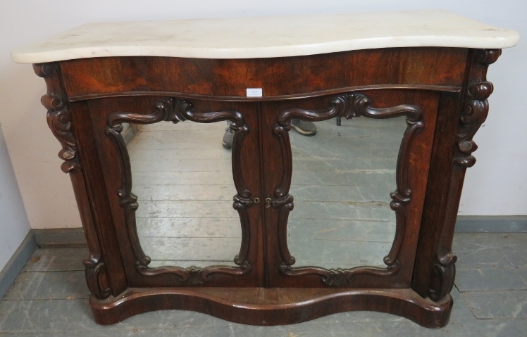 A Victorian rosewood serpentine fronted chiffonier with marble top and carved corbels, flanking