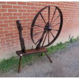 A large 18th century elm spinning wheel, on canted supports.