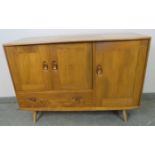 A mid-century ‘Windsor’ elm and beech sideboard by Ercol housing two cupboards, (one with cutlery