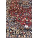A superb Persian Meshed carpet, central motif, blue on red ground with flowers and foliage. 345cm