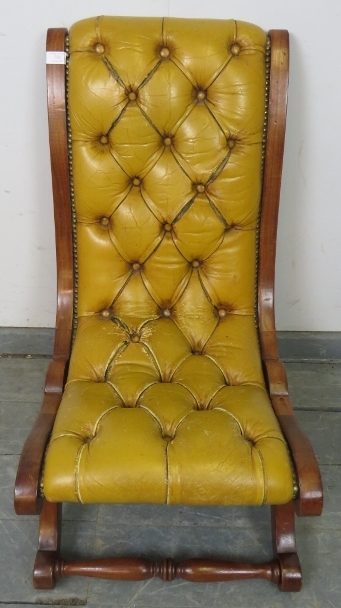 A reproduction mahogany slipper chair, upholstered in buttoned mustard leather with brass studs,