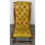 A reproduction mahogany slipper chair, upholstered in buttoned mustard leather with brass studs,