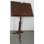 A 19th century mahogany music stand, with ratchet height adjust, on splayed tripod supports.