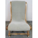 A Victorian beech slipper chair, upholstered in grey material with silver braiding, on scrolled