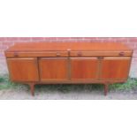 A mid-century teak sideboard by Greaves & Thomas, housing two short drawers over cupboards with