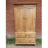 An antique pine linen press/wardrobe, the top section with an array of metal hooks, the base with