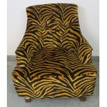 A contemporary armchair, upholstered in buttoned tiger print velvet type material, on tapering