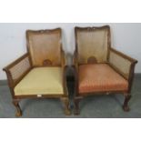 A pair of 1920s walnut his & hers bergère armchairs, on cabriole supports with claw & ball feet.
