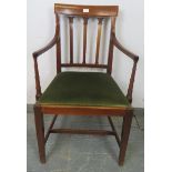 An Edwardian mahogany elbow chair, with inlaid backrest and spindles featuring carved capitals, on