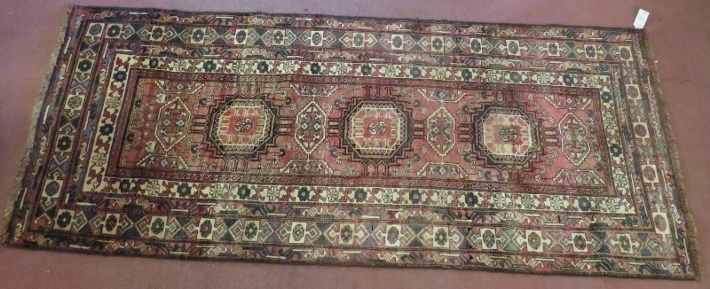 North East Persian Turkoman runner, central panel of motifs on red ground with multi geometric