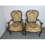 A pair of antique style mahogany open-sided armchairs, upholstered in a textured patterned material,