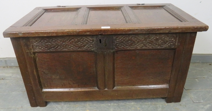 An early 18th century panelled oak coffer of small proportions, with internal candle box and