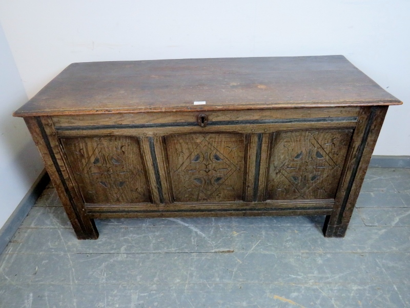An early 18th century panelled oak coffer, with diamond carved front, on stile supports. H66cm