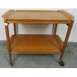 A mid-century teak two-tier drinks trolley, with two removable trays, on castors. H62cm W74cm