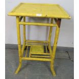 A turn of the century Colonial bamboo two-tier occasional table, painted chrome yellow, on splayed