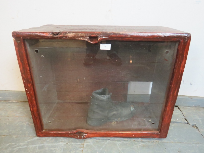 A vintage glazed display cabinet with naturalistic wood surround, currently containing an old