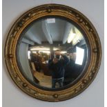 A vintage circular convex mirror with acanthus moulded gilt gesso frame and ebonised reeded