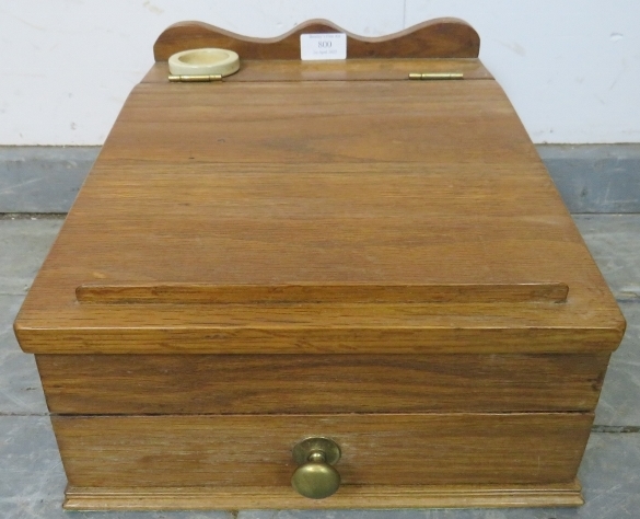 A small vintage medium oak table-top writing slope with ceramic inkwell and divided internal storage