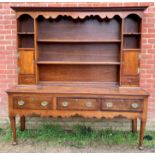 A good 18th century oak Welsh dresser, the top section with dentil cornice and shaped canopy,