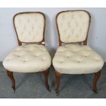 A pair of antique French oak occasional chairs, upholstered in buttoned cream material, on