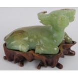 A Chinese carved celadon Jade recumbent water Buffalo, Ming style but likely Qing, resting on a