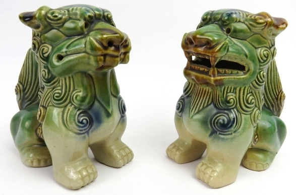 A matched pair of sandai glazed ceramic Buddhistic lions. Both of similar form with incised and